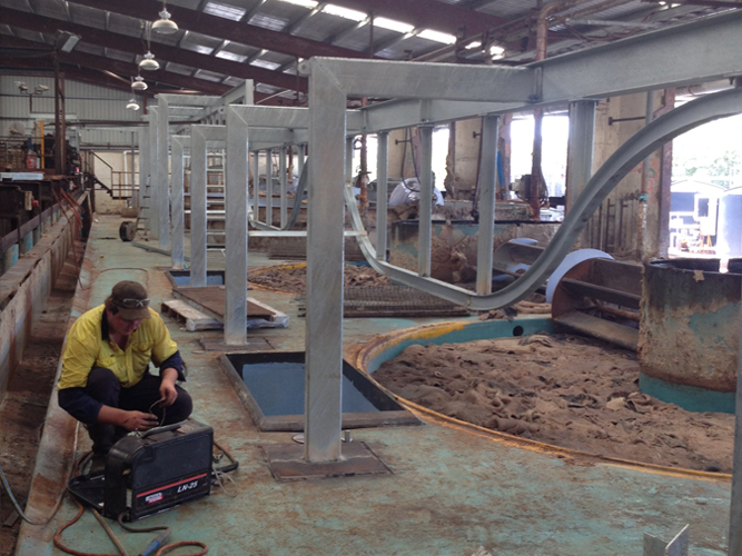 Dunn Metal Works tradesperson fabricating and installing structural steel framework inside an industrial plant