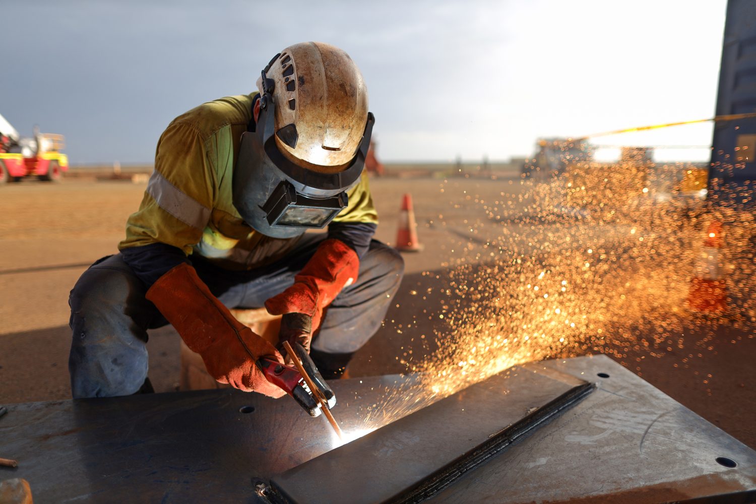 Dunn Metal Works tradesperson welding a steel plate on site, sparks flying, South East Queensland